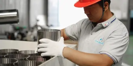 A worker is placing wedge wire tubes into wooden carton.