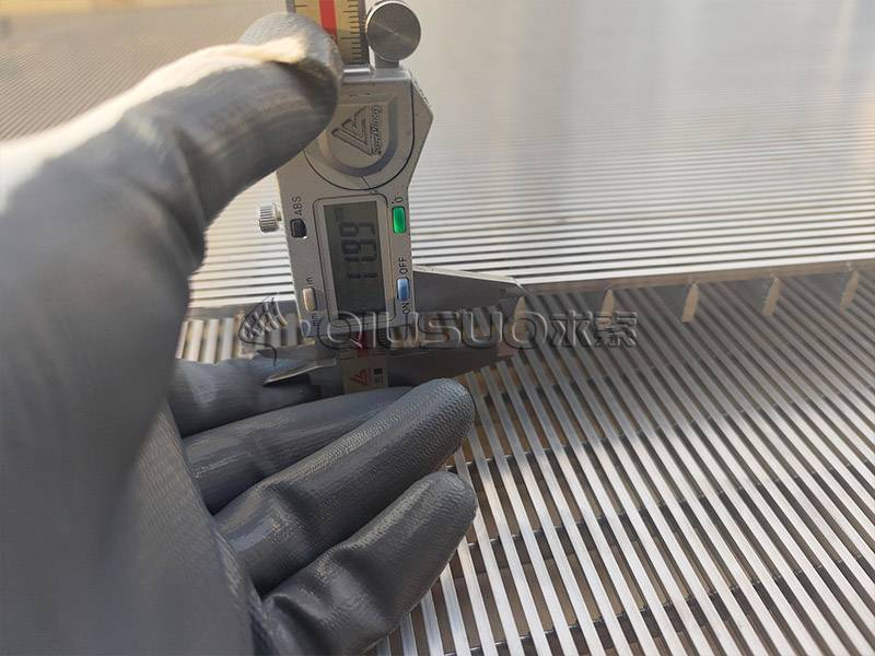 A worker is measuring the support wire height of wedge wire screen panel with caliper.