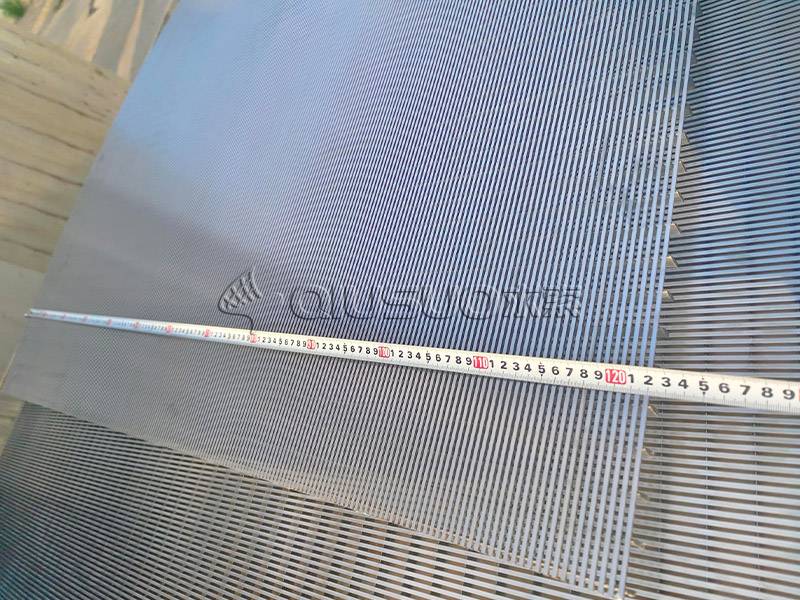A worker is measuring the wedge wire screen panel width with caliper.
