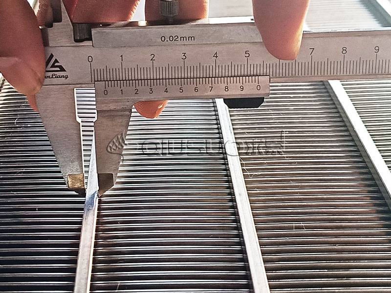 A worker is measuring the support wire width of wedge wire screen panel with caliper.