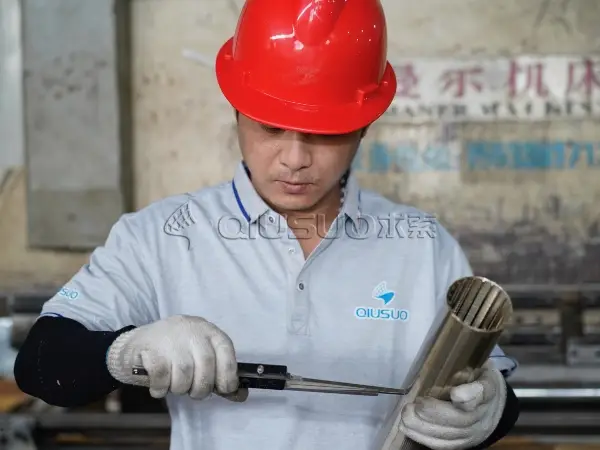 A worker is measuring the wedge wire tube slot size.