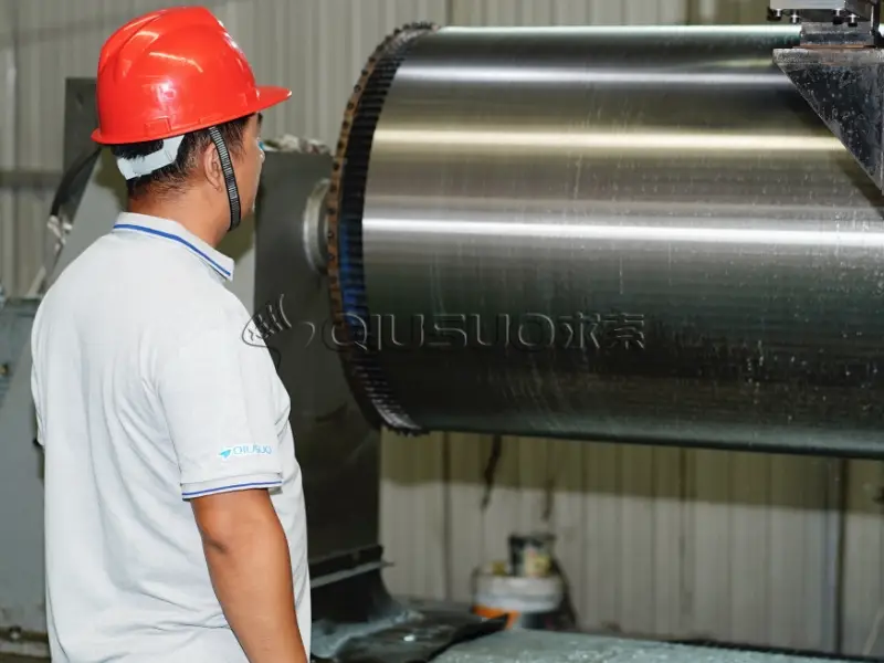 A worker is supervising the wedge wire cylinder production line.