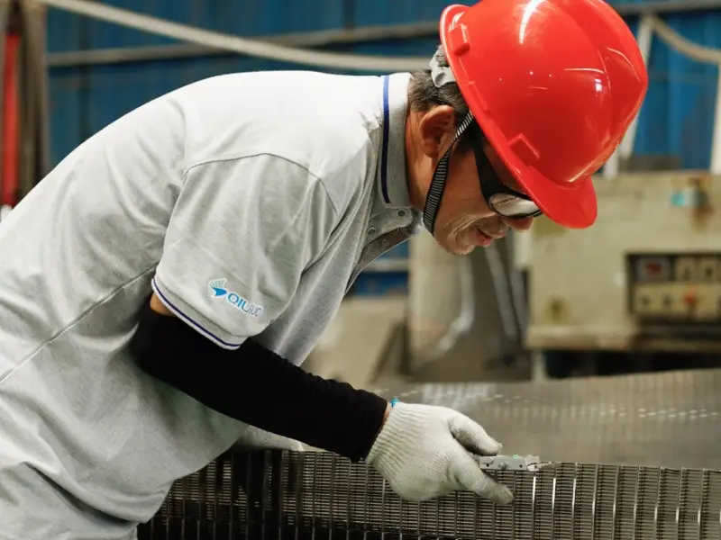 A worker is testing the support rod size of wedge wire screen panel.