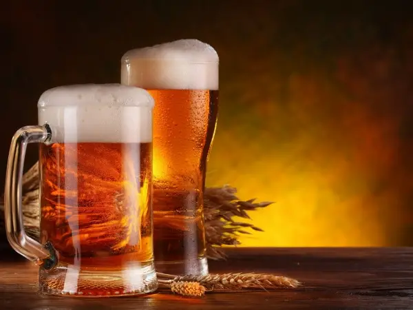 The picture shows two glasses of beer and grains.