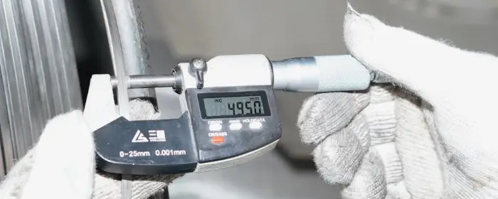 A worker is measuring the wedge wire sizes.