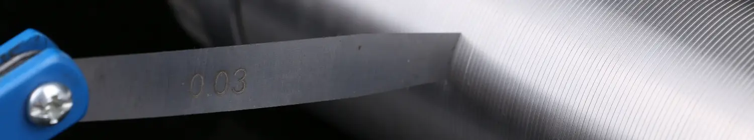 Un lavoratore sta testando gli slot dei tubi dello schermo a cuneo.