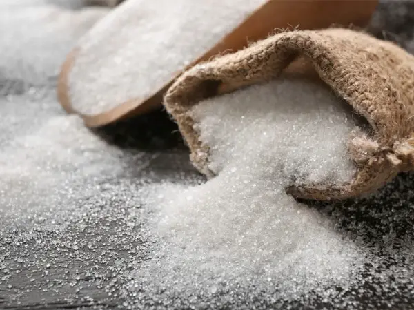 Çuval ve ahşap spatulalar çok sayıda toz şeker ile doldurulur.